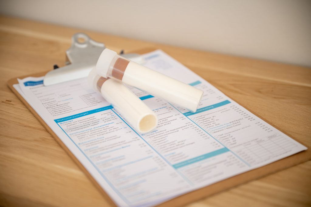 Probenröhrchen auf einem Laborbogen – Symbol für Darmgesundheit und Nährstofftherapie in der Praxis Melina Stock in Mönchengladbach.